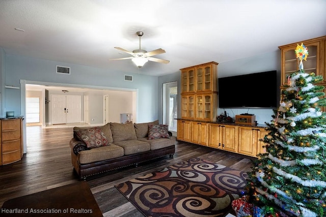 living room featuring ceiling fan and dark wood-type flooring