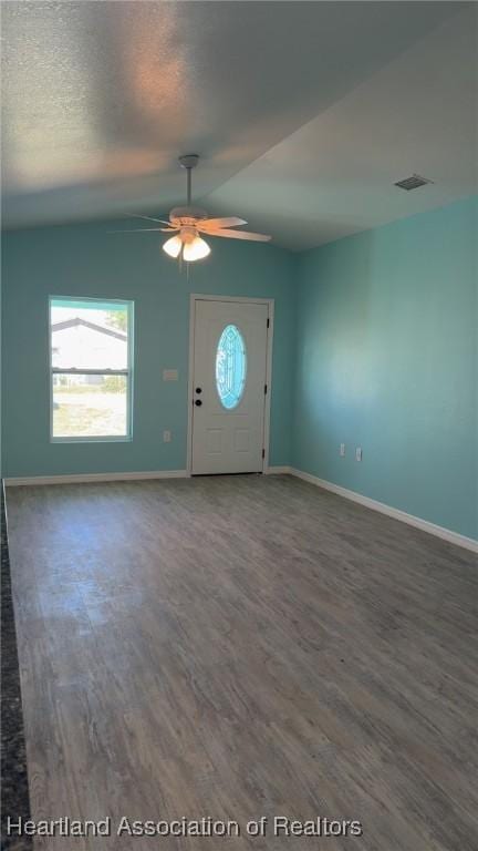 foyer featuring visible vents, baseboards, ceiling fan, wood finished floors, and vaulted ceiling