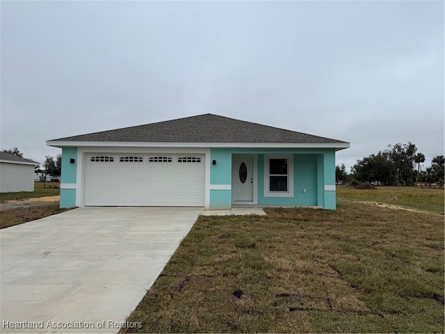 view of front of home with an attached garage, concrete driveway, a front yard, stucco siding, and a shingled roof
