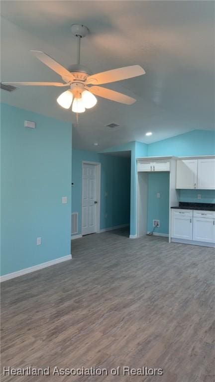 unfurnished living room featuring baseboards, visible vents, wood finished floors, and ceiling fan
