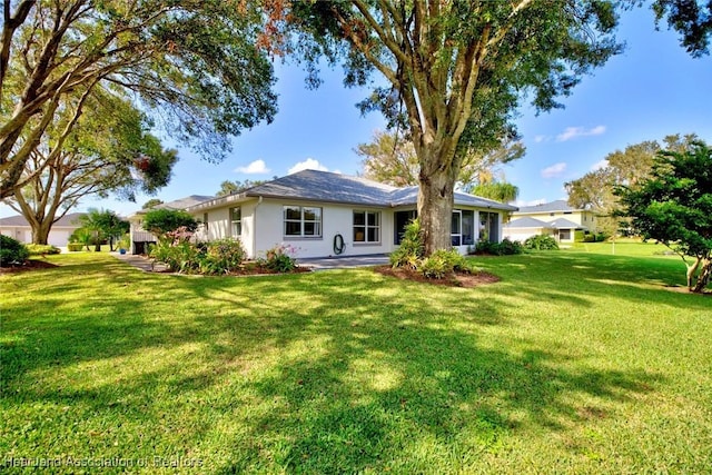 rear view of house featuring a lawn