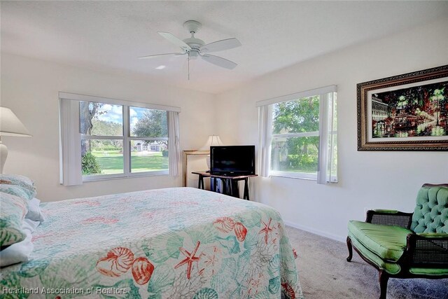 carpeted bedroom featuring multiple windows and ceiling fan