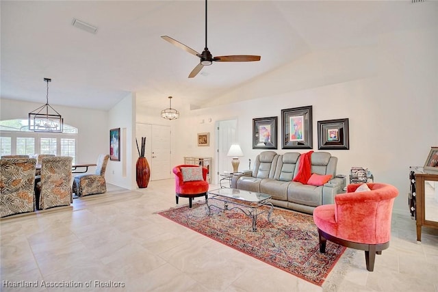 living room with ceiling fan with notable chandelier and vaulted ceiling