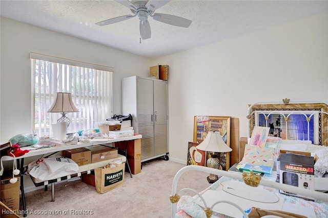 office area with ceiling fan, light colored carpet, and a textured ceiling