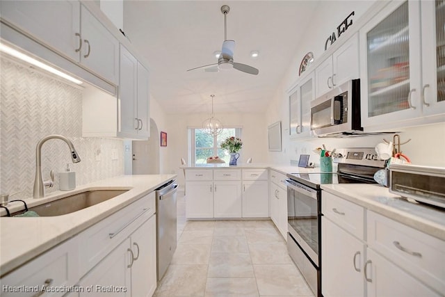 kitchen featuring white cabinets, ceiling fan with notable chandelier, sink, and appliances with stainless steel finishes