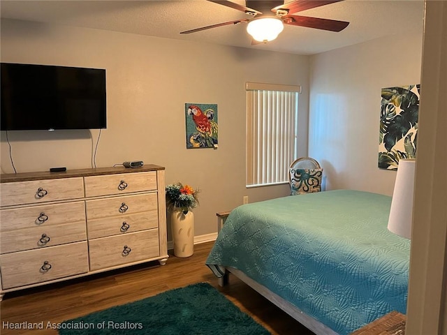 bedroom with ceiling fan and dark wood-type flooring