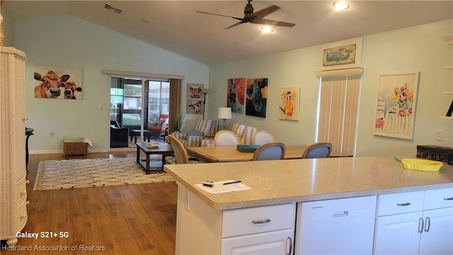 kitchen with white cabinetry, ceiling fan, vaulted ceiling, and light wood-type flooring