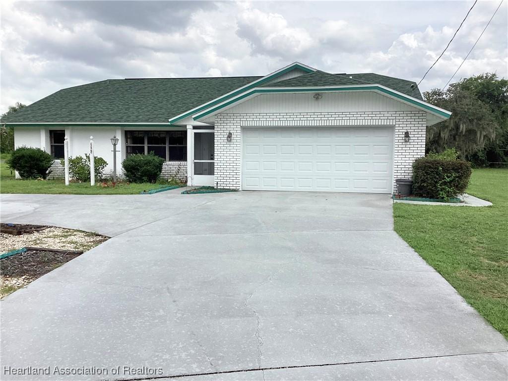 ranch-style house featuring a garage and a front lawn