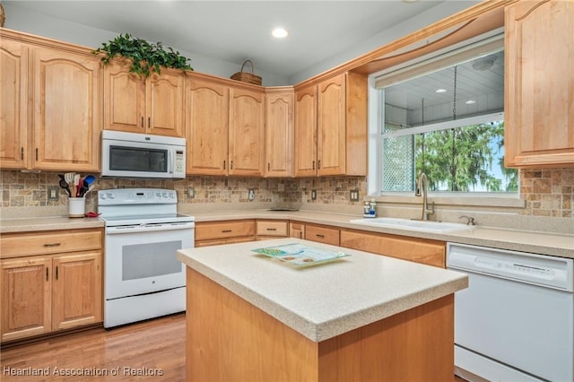 kitchen featuring decorative backsplash, light hardwood / wood-style floors, white appliances, and sink