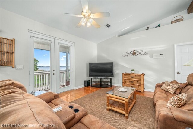 living room featuring ceiling fan, french doors, hardwood / wood-style floors, and vaulted ceiling