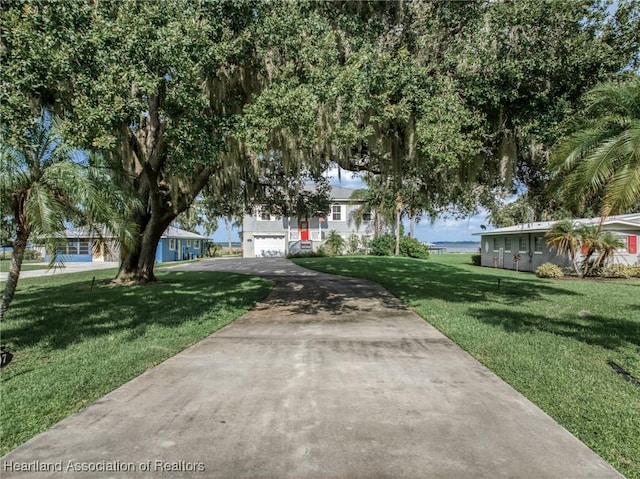 obstructed view of property featuring a front lawn and a garage