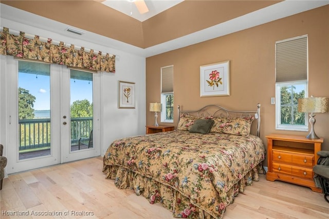 bedroom with access to exterior, light wood-type flooring, and ceiling fan