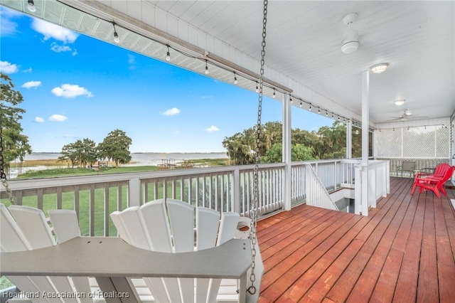 wooden terrace featuring ceiling fan and a water view