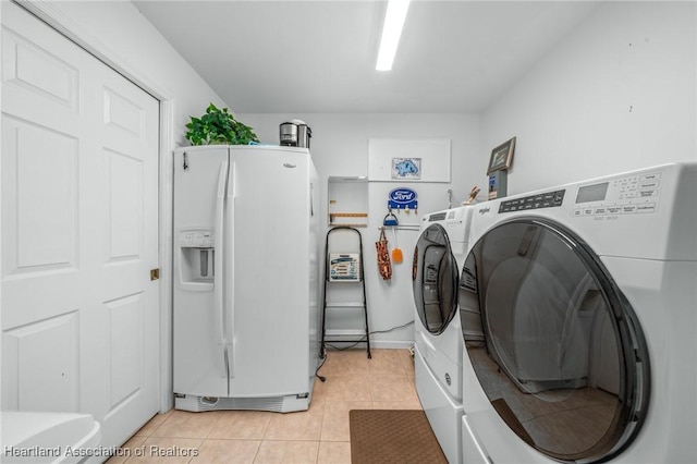 laundry room featuring light tile patterned floors and separate washer and dryer