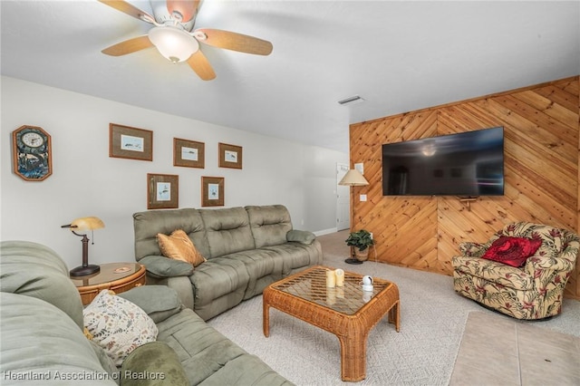 living room with ceiling fan and wooden walls