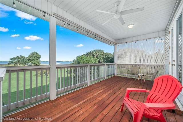 wooden terrace with ceiling fan and a water view