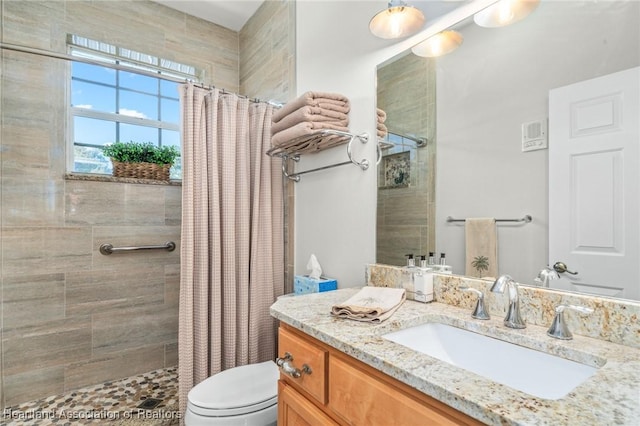 bathroom with toilet, vanity, and walk in shower