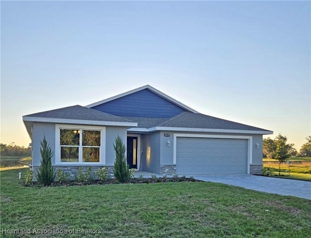 ranch-style house featuring a yard and a garage