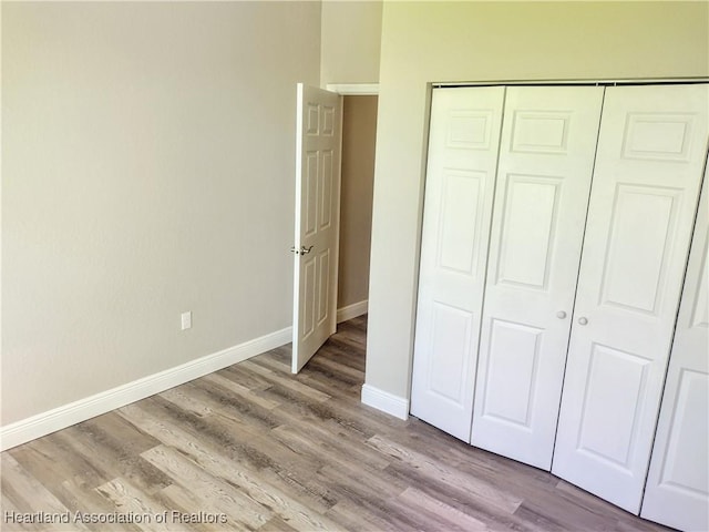 unfurnished bedroom featuring light wood-type flooring and a closet