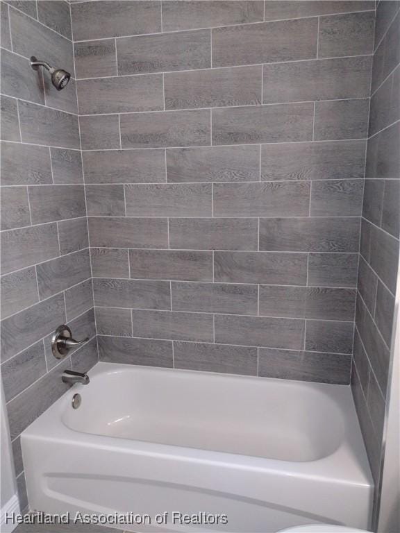 bathroom featuring tiled shower / bath