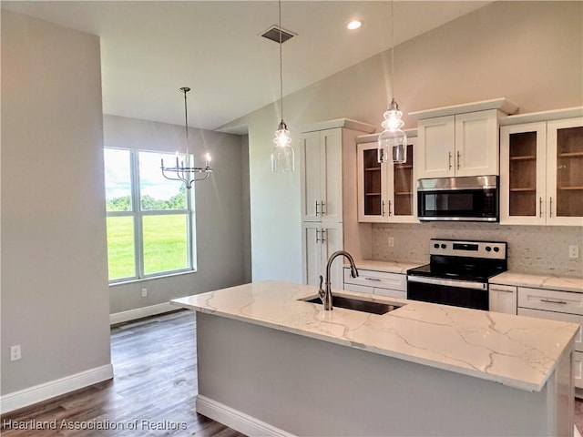 kitchen with white cabinetry, sink, an island with sink, decorative backsplash, and appliances with stainless steel finishes