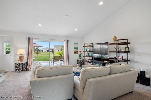 carpeted living room featuring high vaulted ceiling