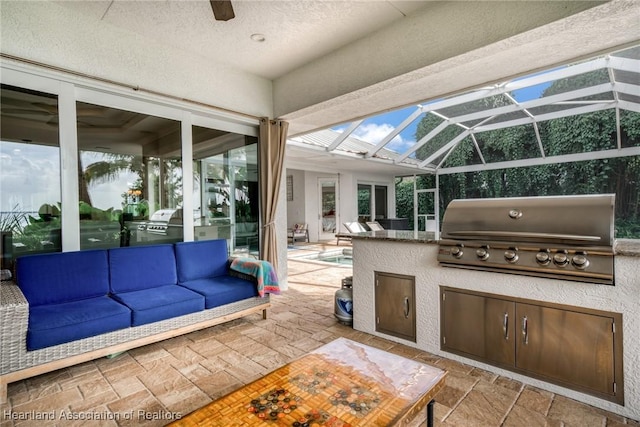 view of patio / terrace featuring grilling area, an outdoor living space, a lanai, and exterior kitchen