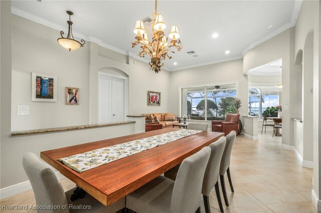 dining space with light tile patterned floors, a notable chandelier, and ornamental molding