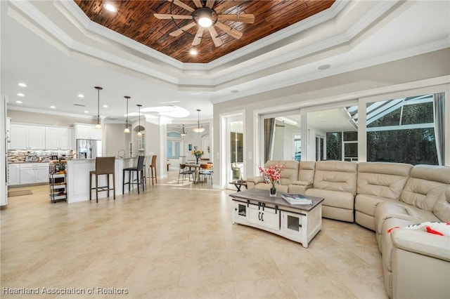 living room with crown molding and a raised ceiling