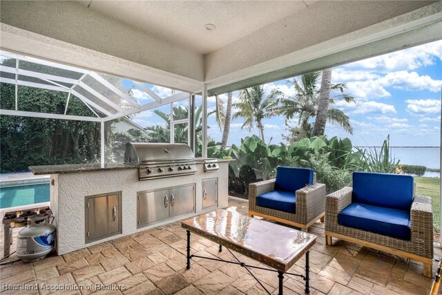 view of patio featuring a lanai, exterior kitchen, and a grill