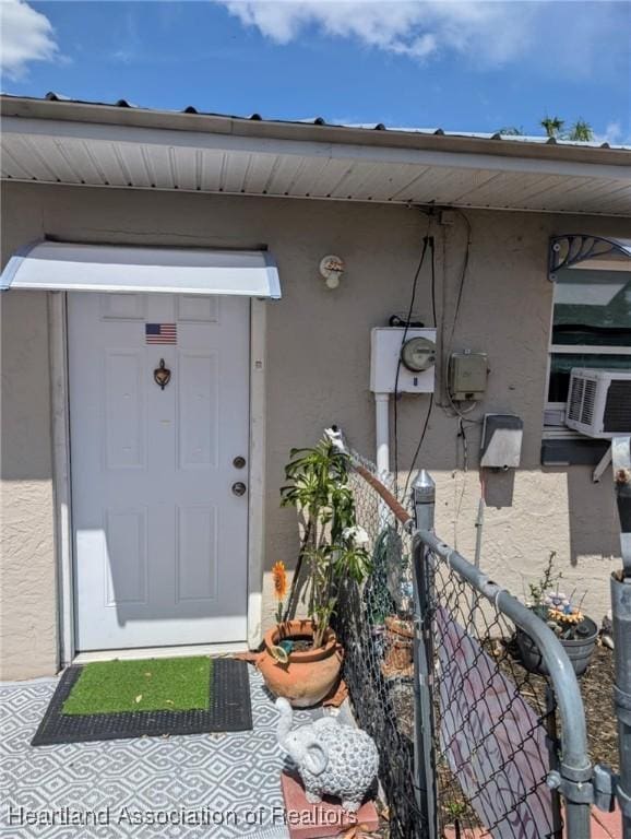 4128 Capri St, Sebring, FL 33872 - entrance to property with fence, stucco siding, and cooling unit