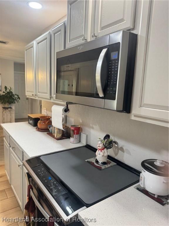 4128 Capri St, Sebring, FL 33872 - kitchen featuring light countertops, recessed lighting, and stainless steel microwave