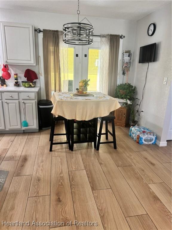 4128 Capri St, Sebring, FL 33872 - dining area with light wood finished floors and a notable chandelier