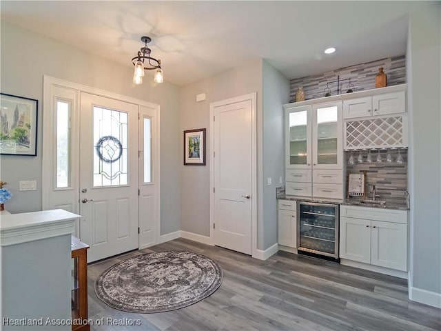 4936 Myrtle Dr, Sebring, FL 33872 - entryway featuring beverage cooler, bar area, dark wood-style floors, a chandelier, and recessed lighting
