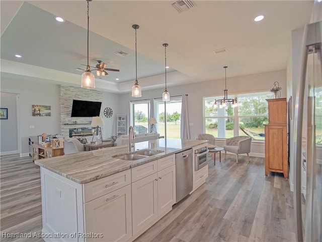 4936 Myrtle Dr, Sebring, FL 33872 - kitchen featuring dishwasher, ceiling fan, a raised ceiling, light wood-style flooring, and white cabinets