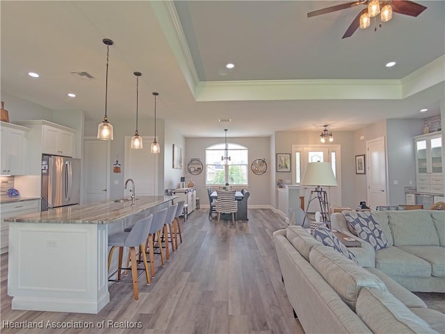 4936 Myrtle Dr, Sebring, FL 33872 - living area featuring a tray ceiling, light wood-style floors, ornamental molding, ceiling fan, and recessed lighting