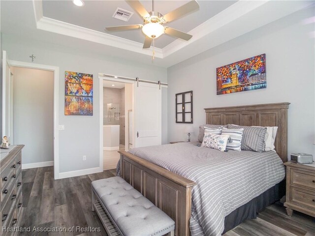 4936 Myrtle Dr, Sebring, FL 33872 - bedroom with a tray ceiling, a barn door, dark wood-type flooring, recessed lighting, and ensuite bath
