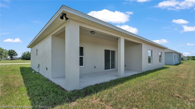 view of side of home featuring a patio and a lawn