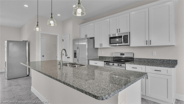 kitchen with pendant lighting, sink, a kitchen island with sink, and appliances with stainless steel finishes