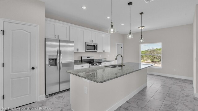 kitchen featuring a kitchen island with sink, white cabinetry, sink, and stainless steel appliances