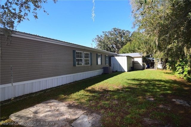 view of yard featuring central AC unit and a storage shed