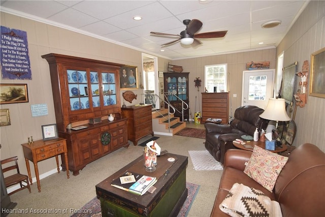 living room featuring light colored carpet, ceiling fan, and crown molding