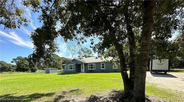 single story home with a front lawn and a storage shed