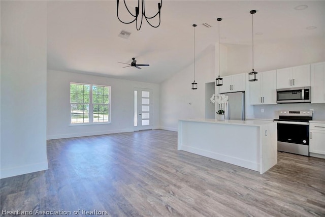 kitchen with white cabinetry, a center island, hanging light fixtures, stainless steel appliances, and ceiling fan with notable chandelier