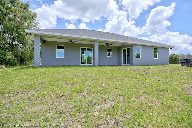 rear view of house with a yard and ceiling fan