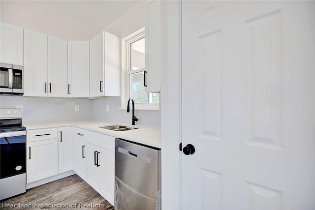 kitchen featuring white cabinets, backsplash, sink, and stainless steel appliances