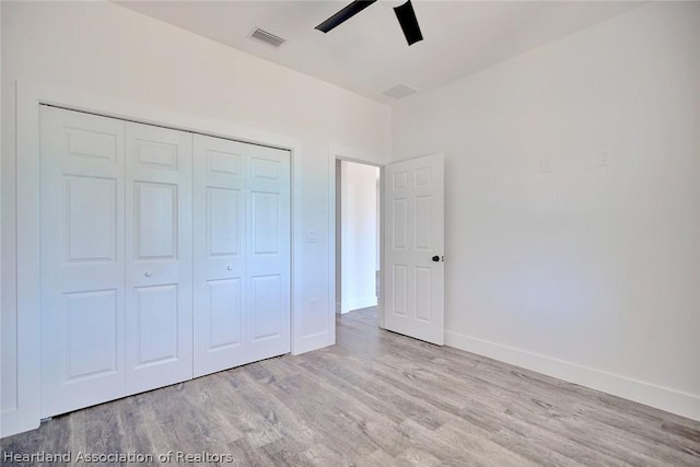 unfurnished bedroom with ceiling fan, light hardwood / wood-style floors, and a closet