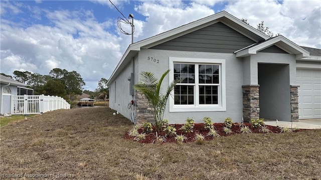 view of side of property featuring a yard and a garage