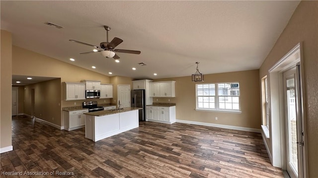 kitchen featuring vaulted ceiling, ceiling fan, an island with sink, appliances with stainless steel finishes, and white cabinetry