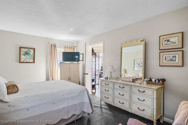 bedroom featuring a textured ceiling and carpet flooring